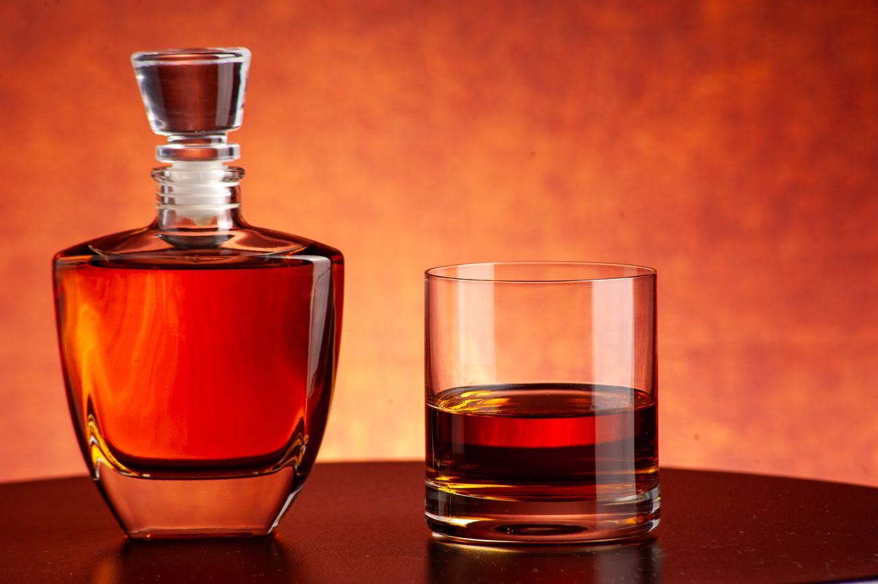 about-us Luxurious whiskey decanter and glass set against a warm, inviting backdrop. Perfect for bars and homes.